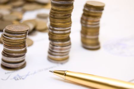 Coins and gold pen on  written contract background の写真素材
