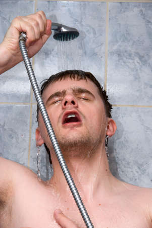 Young handsome man in a showerの写真素材