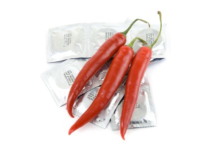 Red peppers on a condom packs over  white background
の写真素材
