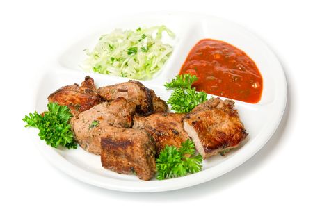 Grilled meat with sauce and vegetables isolated on white backgroundの写真素材