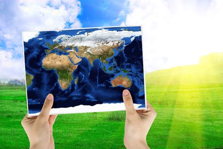 Hand holding map on nature background with sunrise