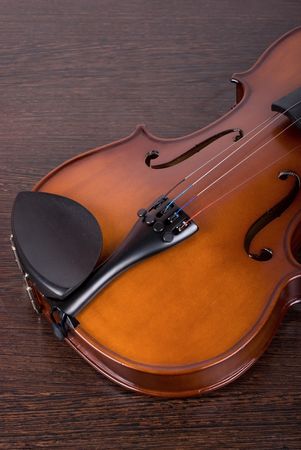 classic violin closeup on a brown wooden backgroundの写真素材
