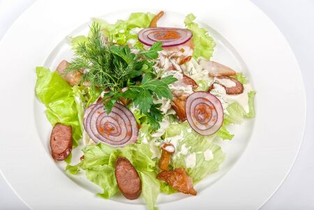 Tasty salad dish close up with sausage and vegetables on a white backgroundの写真素材