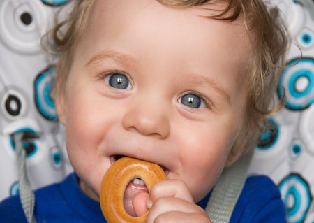 pretty baby boy laughing portrait with bread ringの写真素材