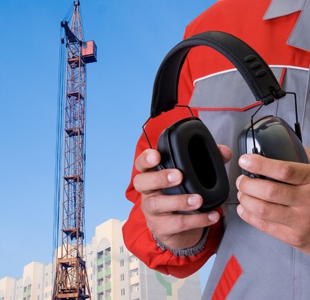 protective headphone at man hands on building backgroundの写真素材