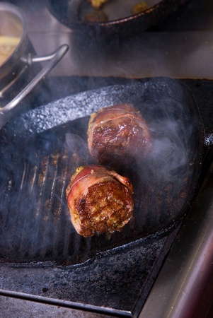 Tasty beef steak grilling in a cast-iron ribbed fry pan