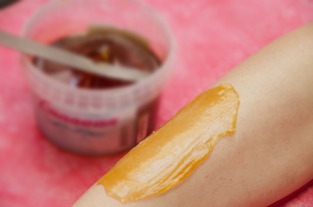 Sugaring: epilation with liquate sugar at legs. It is less painful hair removal with wax replacementの写真素材