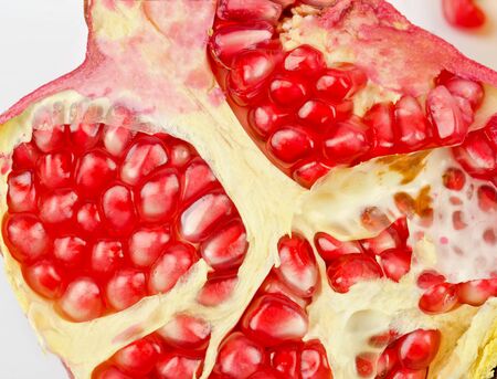 Half of pomegranate closeup on a white backgroundの写真素材