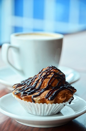 Chocolate muffins with and coffee cup on orange tableの写真素材