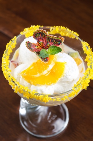 Ice cream dessert with kiwi and orange decorated with butterflyの写真素材