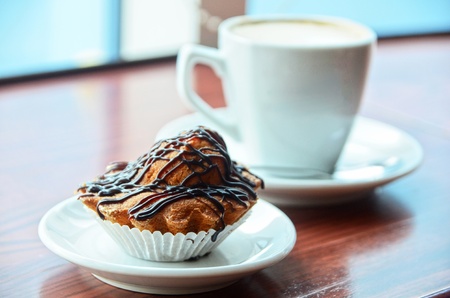 Chocolate muffins with and coffee cup on orange tableの写真素材