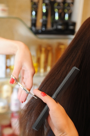 Close up of hairdresser giving haircut to femaleの写真素材
