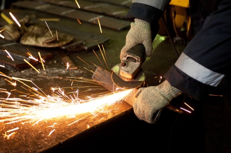 worker welding metal with sparks at factoryの写真素材