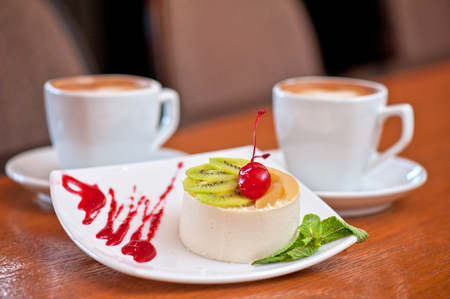 tasty fruit dessert with cherry and kiwi with coffeeの写真素材