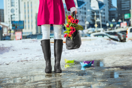 Woman wearing rain boots stay into a puddleの写真素材