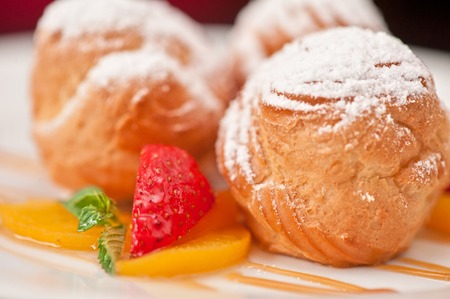 profiteroles from cream and condensed milk decorated with strawberry and peachの写真素材