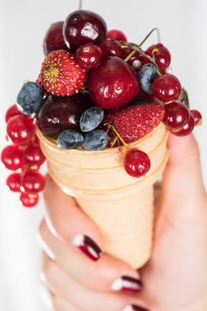 hand holding fresh berries in waferの写真素材