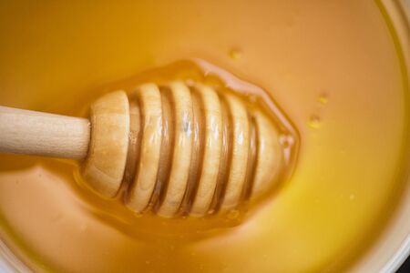 Honey with wooden spoon closeup photoの写真素材