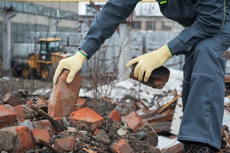 worker takes down blockages of broken bricksの写真素材