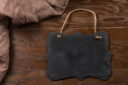 Dark grey black slate board at wooden tableの写真素材