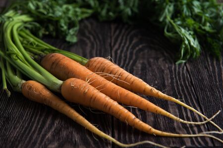 Freshly grown carrots on wooden tableの写真素材