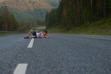Man laying on the roadの写真素材