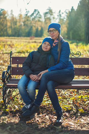 Mother and son at autumn park in sunny beauty dayの写真素材