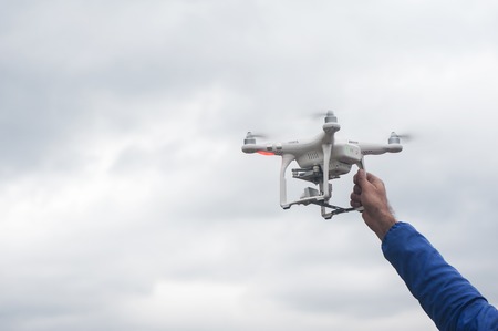 The flying drone copter with digital camera and human handの写真素材
