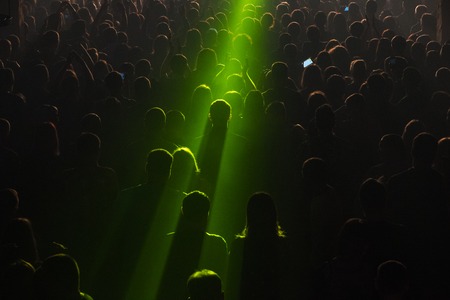 Rock concert crowd people in front of the bright stage lights