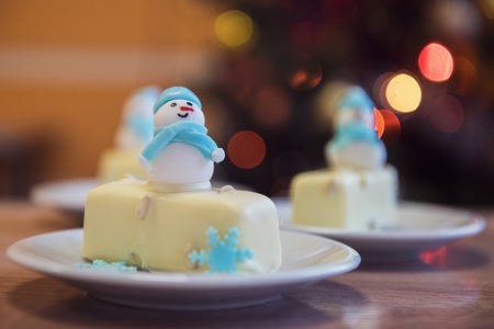 Christmas dessert with snowman on lights bokeh backgroundの写真素材