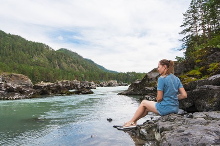 Woman resting at river in Altai Mountains territoryの写真素材