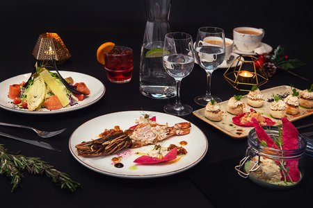 Tasty restaurant dishes: Cooked and stuffed crayfish, salad, appetizers, and crayfish ice-creamの写真素材