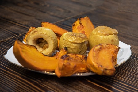 Baked pumpkin and apples on plateの写真素材