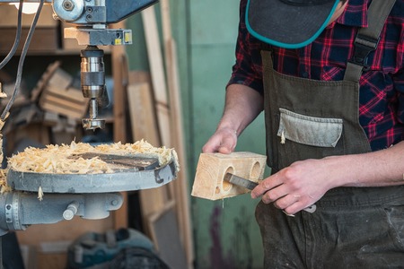 Carpenters with electric drill machine drilling wooden board at workshop. Profession, carpentry and woodwork concept.の写真素材