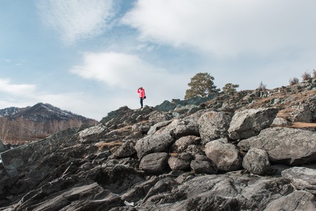 Happy woman relaxing on the top of mountain at beauty sunny spring day, in Altai mountains. Travel vacation concept.の写真素材