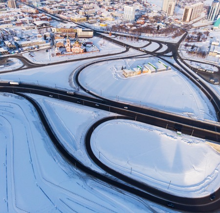Aerial shot of road and cars driving on the road, winter sunny day in Barnaul, Siberia, Russiaの写真素材