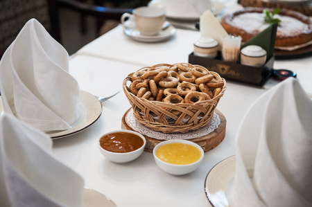 Traditional russian baked goods: pies and pretzels, samovar, honey, jam on the served tableの写真素材