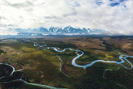 Kurai steppe and Chuya river on North-Chui ridge background. Altai mountains, Russia. Aerial drone...
