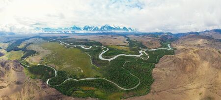 Kurai steppe and Chuya river on North-Chui ridge background. Altai mountains, Russia. Aerial drone panoramic picture.の写真素材