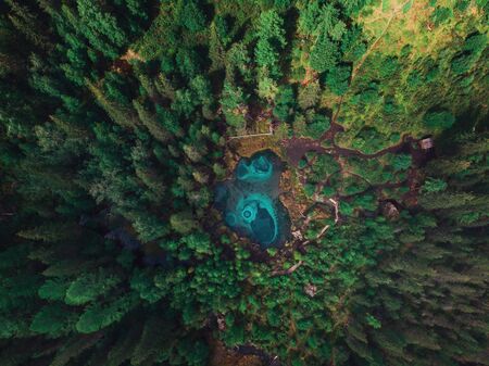 Beautiful Geyser (blue, silver) lake with thermal springs that periodically throw blue clay and silt from the ground. Aerial drone view. Aktash, Altai mountains, Russiaの写真素材