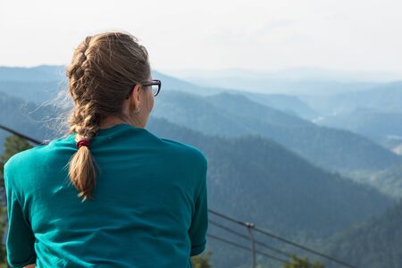 Woman standing and looking into the distance in mountains
