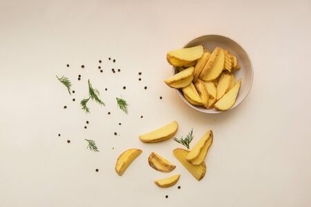 Crisp golden fried french fries potatoes in color background, top view