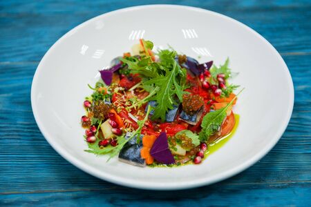 Escabeche fish dish with caviar: mackerel in marinade with vegetable, on a plate on the wooden blue background.の写真素材