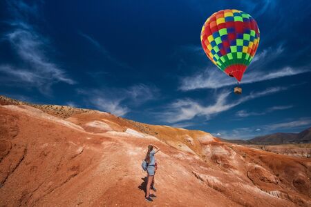 Woman with her son in valley of Mars landscapes in the Altai Mountains, Kyzyl Chin, Siberia, Russia, Aerostat in the sky.の写真素材