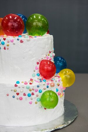 Wedding cake with balloons on grey background