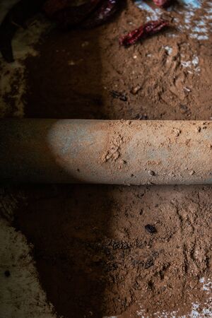 Grinding cacao beans with chili peppers to make chocolate by stone rolling pin on stone surface. hand made chocolate.の写真素材