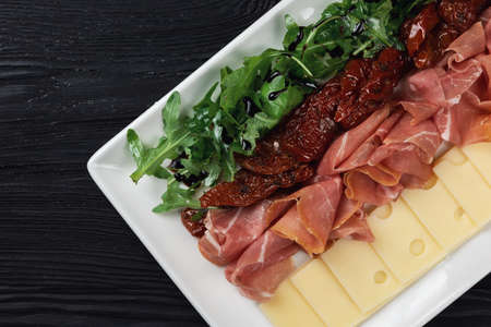 Plate with prosciutto cheese and sun-dried tomatoes