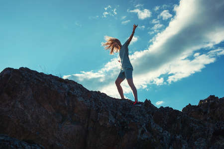 Domestic tourism, travel, lesure and freedom concept after pandemic- woman on the top of Altai mountain, beauty summer evening landcapeの写真素材