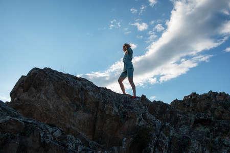 Domestic tourism, travel, lesure and freedom concept after pandemic- woman on the top of Altai mountain, beauty summer evening landcapeの写真素材