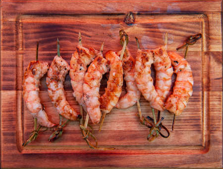 A professional cook prepares shrimps on the grill outdoor, food or catering conceptの写真素材